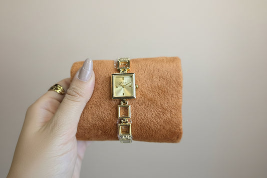 Gold open square watch with gold dail